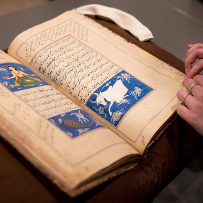 Hands flip through an ancient Persian book of practical magic in the Yale Beinecke collection