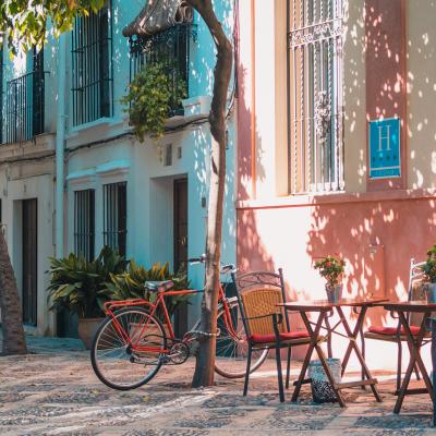 An outdoor cafe and a bicycle parked on a quiet street in Sevilla